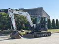 A 2010 Bobcat E80 compact excavator with a bucket attachment and tracks designed for digging and earthmoving tasks