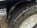 Close-up of two well-treaded tires from a 2013 Ford Econoline displaying deep grooves and a shiny rim