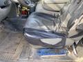 The driver's seat of a 2009 Dodge Ram 5500 featuring a black seat cover and worn upholstery on the armrest with a broom placed on the floor beneath the seat