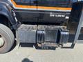 A 1996 GMC Top Kick truck's rear with a black and orange paint scheme showing the fuel tank and step area