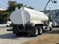 A white 2008 Peterbilt 340 tanker truck with a large cylindrical tank and two axles parked on a gravel surface