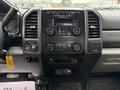 A dashboard of a 2018 Ford F-550 featuring various controls including a radio display and buttons for climate control and vehicle settings