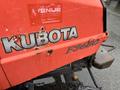 A red Kubota F3680 tractor with worn lettering and visible rust marks on the body