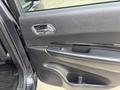 A close-up view of the driver side door panel of a 2015 Dodge Durango featuring a window control button and a textured black surface