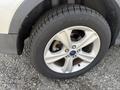 A close-up of a silver and black tire mounted on a 2015 Ford Escape showing the wheel's alloy design and tread pattern