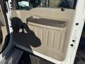 A gray interior door panel of a 2009 Ford F-550 featuring a handle and vertical panel design