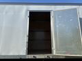 A 2022 Lion Lion6 vehicle with an open side door revealing an empty interior space with wooden flooring and metal reinforcement strips along the walls