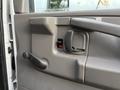 Close-up of the door handle and window control of a 2015 GMC Savana with a gray interior and a simple design