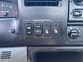 Interior dashboard controls of a 2004 Ford F-750 featuring buttons for cruise control with labels for off resume set and another toggle switch