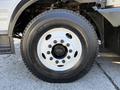 Close-up of a 2012 Autocar XPERT tire mounted on a wheel with multiple lug nuts and a white rim