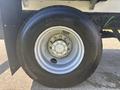 Close-up of a wheel and tire of a 2022 Freightliner M2 106 featuring a silver rim and black rubber tire with tread detail