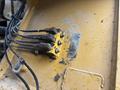 Close-up of a yellow hydraulic connection panel with four numbered ports and dirt on the surface of a 2012 Caterpillar 980