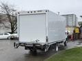 A 2024 Ford E-450 box truck with a white rear door and visible bumper details is parked with its back facing the viewer