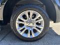 A close-up view of a chrome alloy wheel from a 2015 RAM 1500 truck featuring a multi-spoke design and an all-season tire with tread pattern details