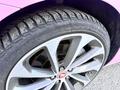Close-up of a silver alloy wheel with a Jaguar logo featuring a black tire with visible tread patterns