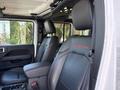 Interior view of a 2021 Jeep Wrangler showing black leather seats with red stitching and "RUBICON" logo on the headrest