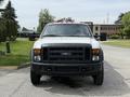 A white 2008 Ford F-550 truck with a black grill and front bumper, featuring orange lights on the roof and a flat front design