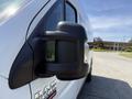 A white 2021 RAM Promaster van with a side mirror and the RAM logo visible on the door panel