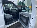 A 2015 Ford F-550 interior with a gray bench seat and dashboard visible through an open driver's side door