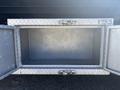 An empty silver diamond plate tool storage box with two compartments and metal latches on the front