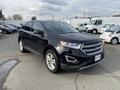 A black 2017 Ford Edge parked on a lot featuring a sleek design with a prominent front grille and stylish headlights