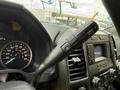 The interior of a 2018 Ford F-150 featuring a steering wheel with controls for drive mode and a dashboard display showing speed and other gauge readings