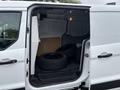 A 2019 Ford Transit Connect van with its side door open displaying four black tires inside the cargo area