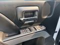 Close-up of the driver side door panel of a 2017 Chevrolet Silverado 1500 featuring door handle and control buttons for window and lock functions