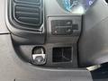 A 2023 RAM Promaster 3500 dashboard featuring control buttons and air vents with a small compartment below the buttons