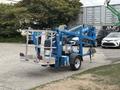A blue 2016 Genie TZ-34/20 articulated boom lift with a platform mounted on a trailer chassis facing away from the viewer