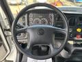 Steering wheel of a 2013 Freightliner 114SD with visible dashboard instruments and controls including gauges and buttons