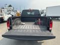 A 2015 RAM 1500 truck with an open bed showing a few tools and a cloth inside