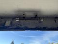 Close-up of a metal bar with brackets mounted above a vehicle's interior door frame designed for securing or operating the door mechanism