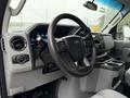 Interior of a 2022 Ford Econoline featuring a steering wheel dashboard controls and console with cup holders