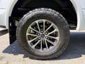 A close-up of a 2018 Ford F-150 wheel featuring a silver aluminum alloy rim and a rugged all-terrain tire with deep treads