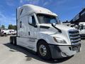 A 2022 Freightliner Cascadia semi-truck with a sleek white exterior and distinctive aerodynamic design parked with its cab facing the viewer