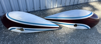 Two teardrop-shaped aircraft fuel tanks in maroon and white with blue stripes designed for a 1986 Sorrell Hiperbipe SNS-7 Amateur-Built Aircraft