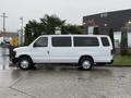A white 2013 Ford E-350 van parked on a wet surface with rain droplets visible on the vehicle