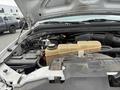 A 2004 Ford F-350 SD engine compartment showing the engine components and coolant reservoir with a yellowish container