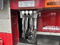 A set of hydraulic control valves with multiple hoses connected to a red and silver truck chassis