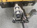 Close-up of a 2010 Vermeer Corporation BC1000XL chipper's hitch with a black coiled cable and a metal connector attached to a support beam