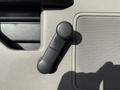 A black plastic window crank handle mounted on a light-colored door panel of a 2020 Ford F-550