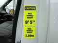 A caution sign on a 2017 Ford Transit indicating the maximum vehicle height of 9 feet 5 inches and 2.89 meters