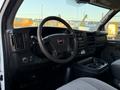 Interior view of a 2015 GMC Savana showing the dashboard steering wheel and center console with cup holders