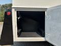 A 2006 Sterling Acterra with an open storage compartment revealing an empty interior and sliding tracks for equipment placement