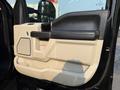 The interior door panel of a 2021 Ford F-350 SD featuring a combination of beige and black materials with a textured handle and control buttons