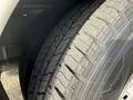 Close-up of a worn tire belonging to a 2002 Ford Econoline displaying visible tread patterns and age-related wear