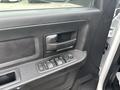 Interior door panel of a 2016 RAM 1500 featuring a black handle and window control buttons