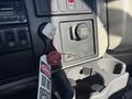 The dashboard of a 2013 International 7500 featuring control buttons a key ignition and a cup holder with a warning tag attached