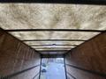 Interior view of a 2012 Mitsubishi Fuso FE truck with a wooden paneling and a textured ceiling visible from the rear entrance